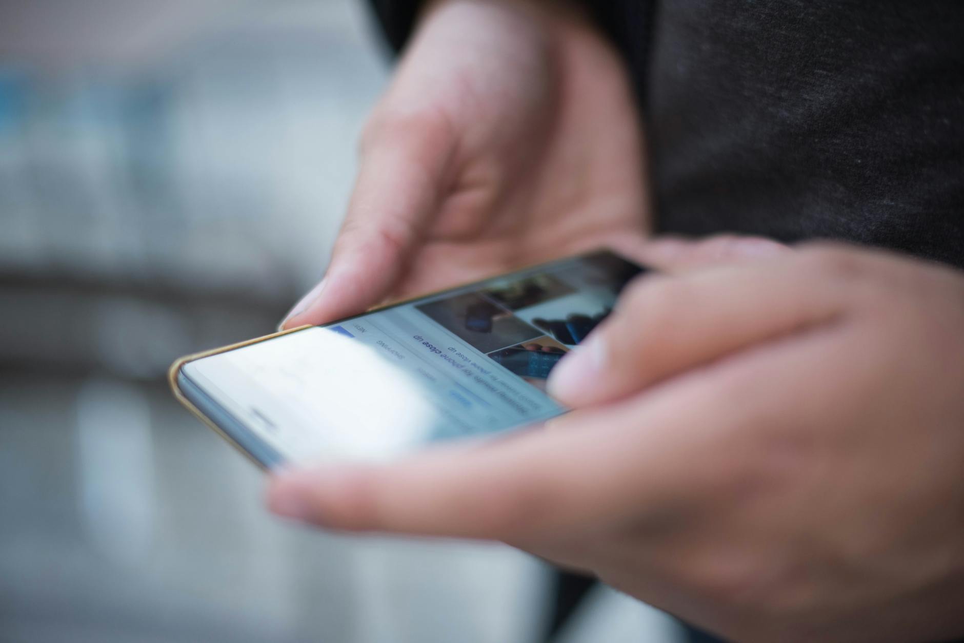 person using smartphone shallow focus photography